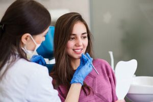 teen girl learning to brush your teeth with braces